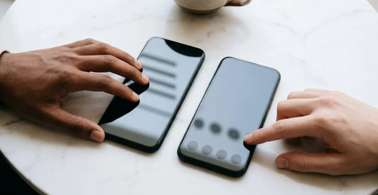 Mains tenant deux smartphones côte à côte montrant des interfaces de navigation différentes